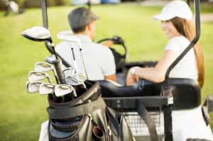 young couple at golf cart enjoying golf benefits